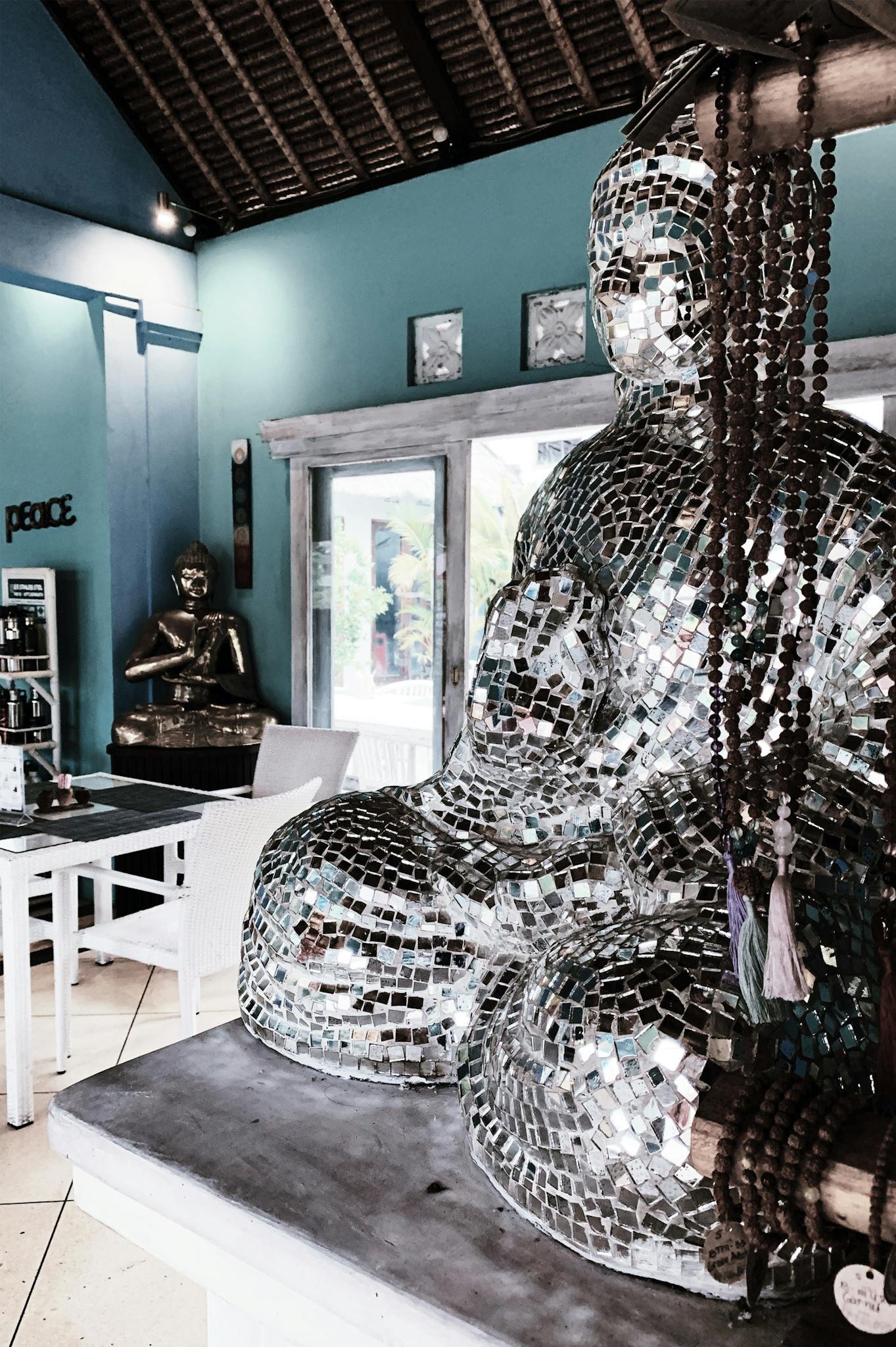 A contemporary reflective Buddha sculpture in a modern, peaceful interior setting.